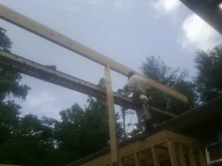 Carpenter setting a ridge beam over a new addition frame — Ice Dam Removal by Roofing Brothers in Rush City