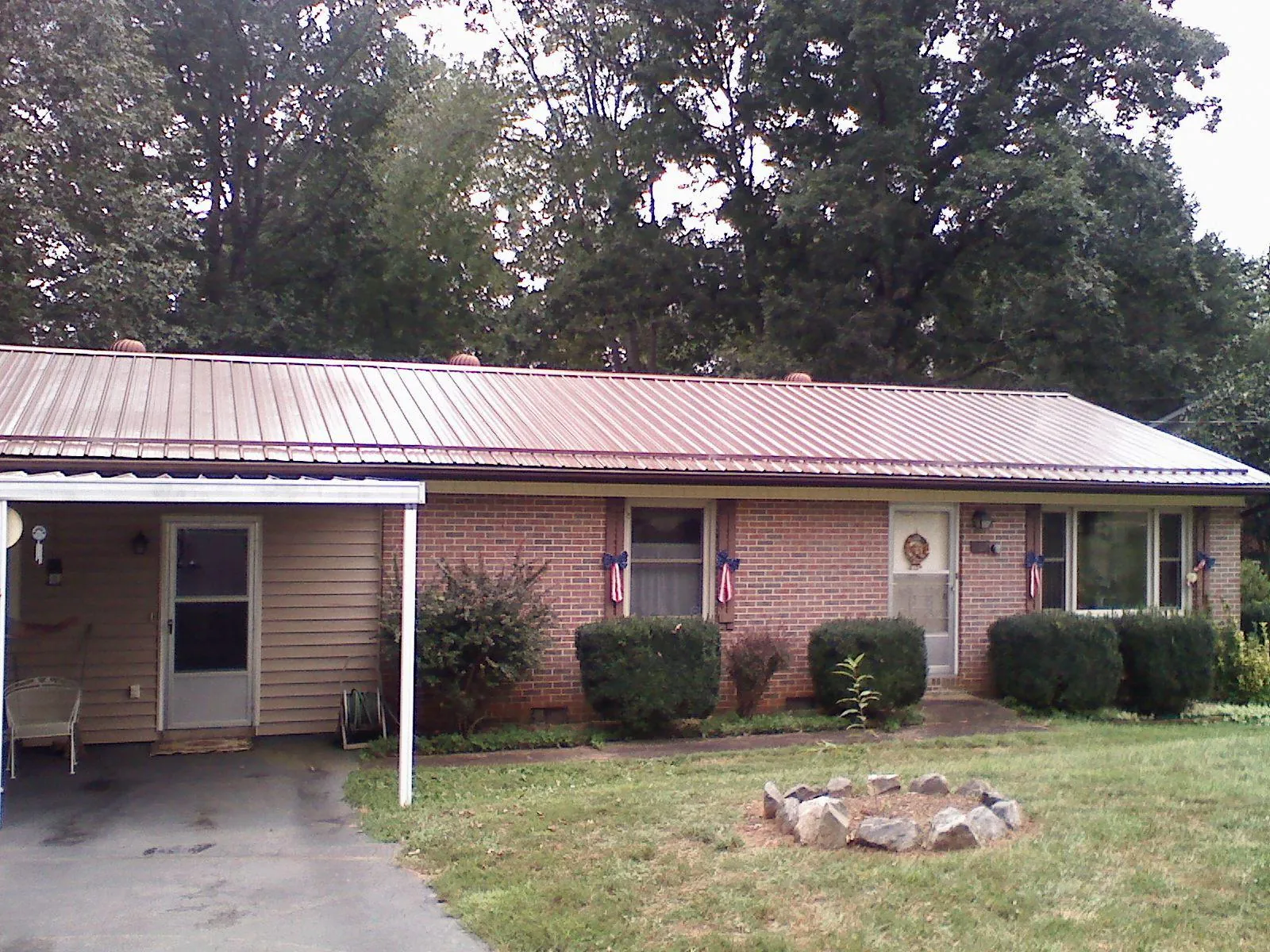 Bronze metal roof and carport on a brick ranch home — Roof Repair work by our crew in Rush City